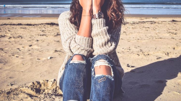 Femme assise avec les mains sur le visage